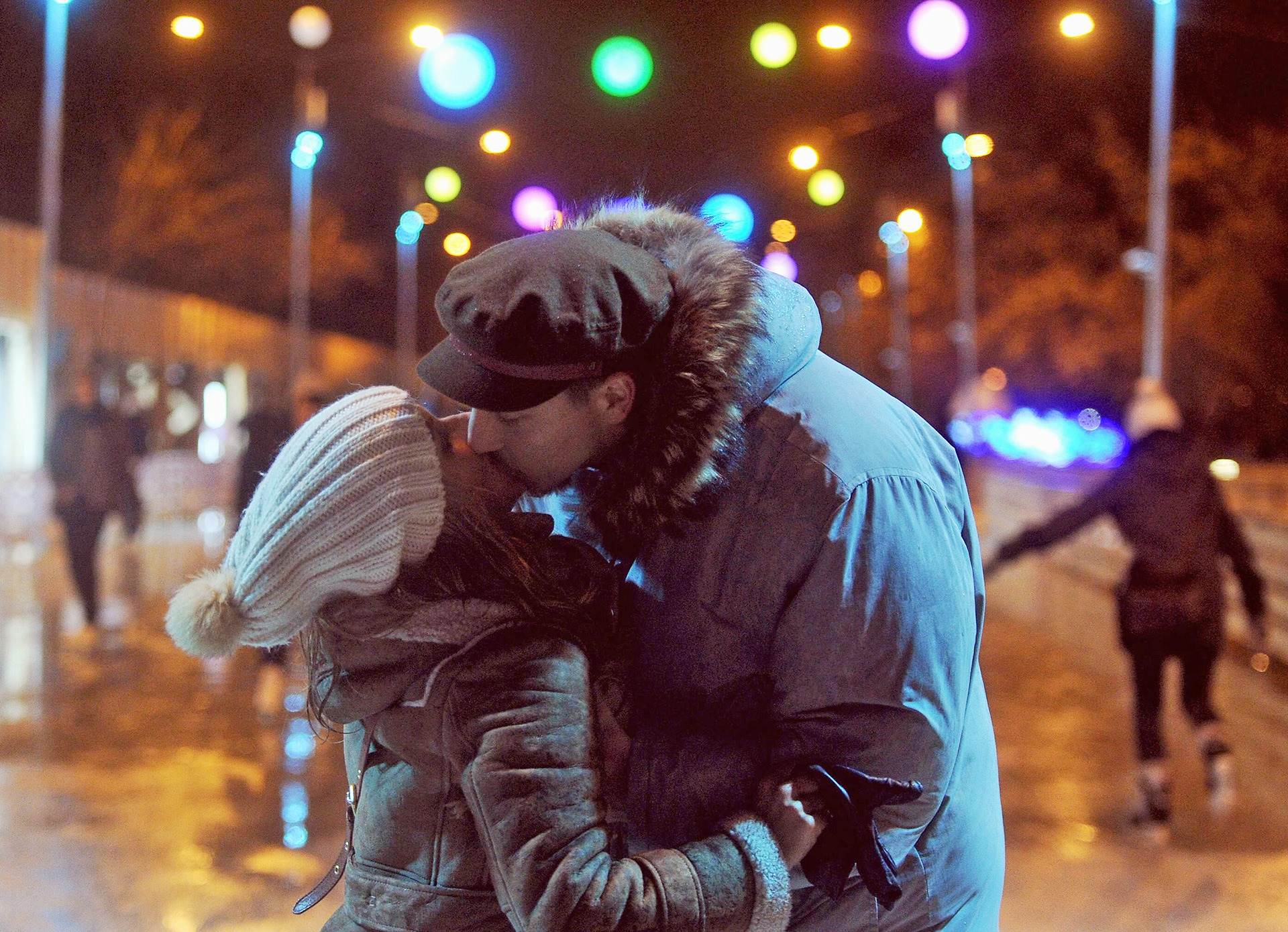 Парень целуется на улице. Пара зимой. Поцелуй на улице. Поцелуй вечером на улице. Пара вечером на прогулке.